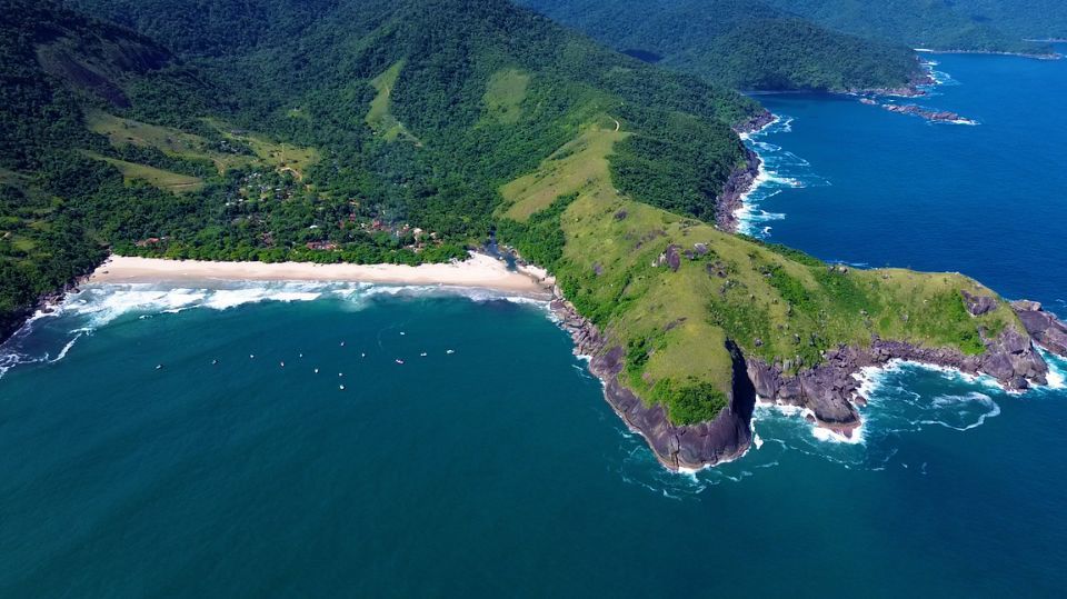 Vista aérea de praia e costão em Ilhabela
